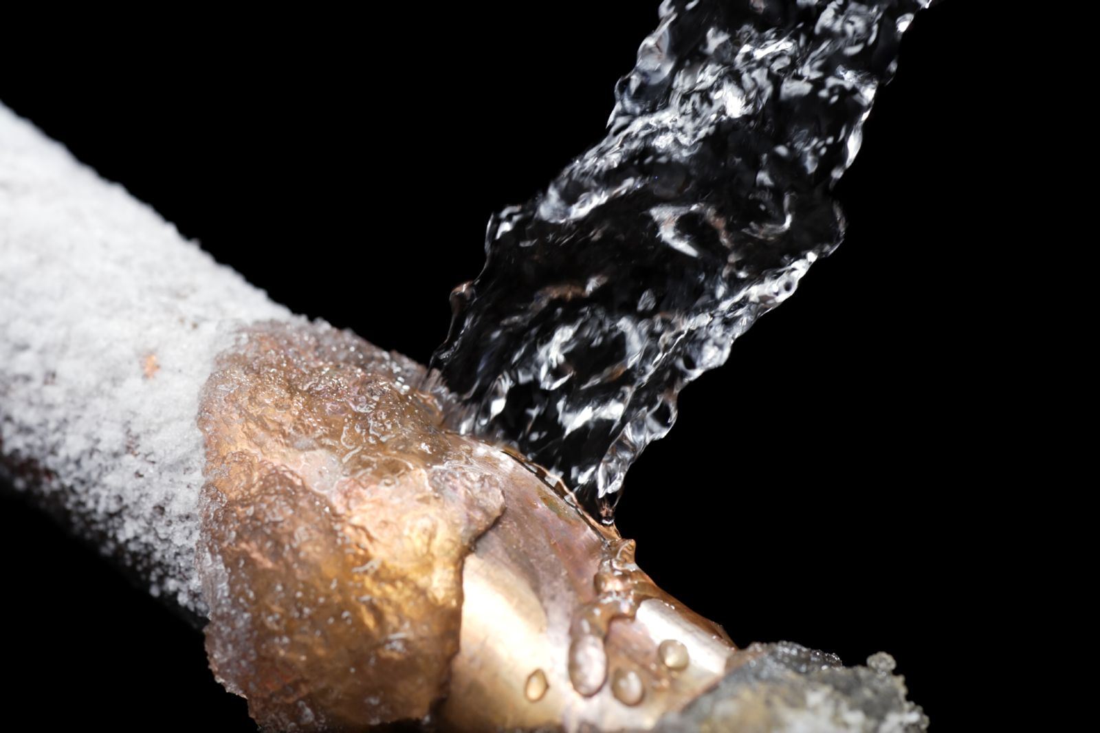 Water pouring onto frozen copper pipe
